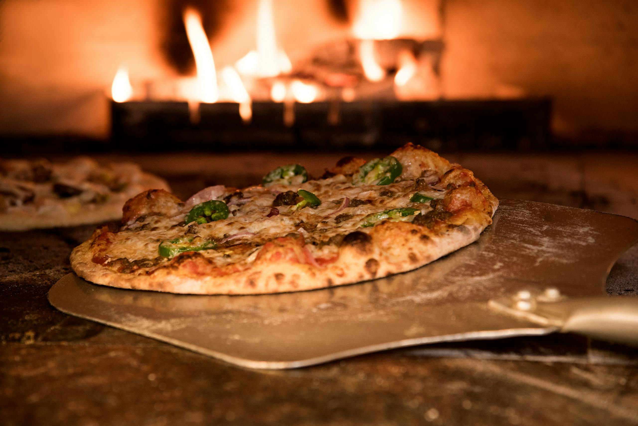 Appetizing gourmet pizza cooked in a wood-fired oven, showcasing artisanal toppings.